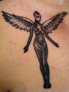 an angel tattoo on the back of a woman's shoulder and chest, with wings spread out