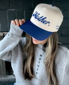 Meet your new favorite, everyday hat. "Mother." is embroidered in 3D across the front with "Strong as a mother" embroidered on the side. Wear as a reminder of your incredible strength. Features: Color: Royal Blue/Cream "Mother." in 3D embroidery in Royal Blue "Strong as a mother" is embroidered on the wearers left Mid profile, structured firm front panel Designed and stitched in the USA Adjustable snapback closure 65% Polyester, 35% Cotton We donate 10% of our proceeds to charitable organization Casual Blue Hats With Embroidered Logo, Spring Blue Hats With Embroidered Logo, Blue Hats With Embroidered Logo, Blue Embroidered Logo Dad Hat, Blue Cotton Snapback Hat With Embroidered Logo, Trending Hats, Canvas Hat, Charitable Organizations, Hat Shop