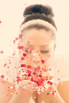 a woman blowing confetti on her face with the caption happy valentine's day