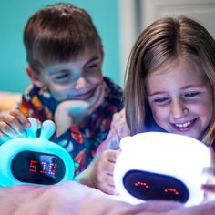 two children are playing with an alarm clock