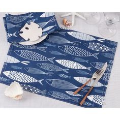 a place mat with fish on it and a fork next to the rest of the table