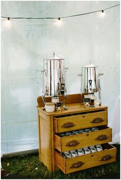 an old dresser with two coffee pots on top and three cups in the bottom drawer