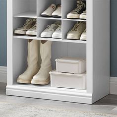 a white shoe rack with several pairs of shoes on top and one pair of boots in the bottom