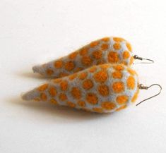 two orange and white felt bird ornaments on silver earwires against a white background