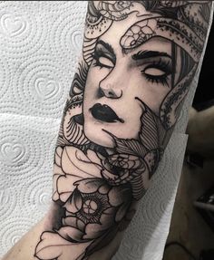 a woman's face with flowers on her arm