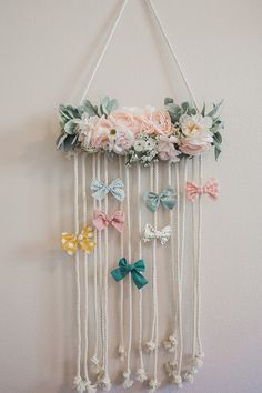 a wall hanging with flowers and bows on it