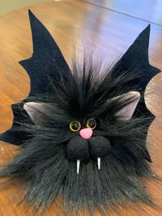 a close up of a stuffed animal on a wooden table with text overlay that reads, how to make an adorable black cat out of fake fur