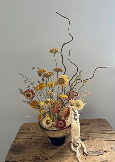 a bowl filled with flowers on top of a wooden table