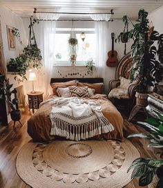 a bedroom with lots of plants in the corner and a rug on the floor next to the bed