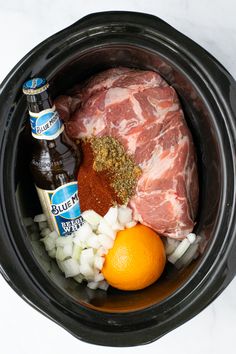 the crock pot contains meat, onions, and beer