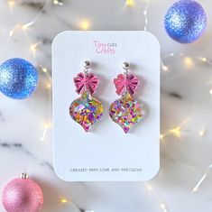 Christmas Ornament chunky Glitter Earrings adorned with a sparkling pink mirror acrylic bow. Crafted from acrylic glitter in vibrant metallic mixed shades of pastel colors,  these earrings feature an eye-catching pink mirror acrylic bow and are made of durable acrylic with stainless steel findings. Measuring 1.60 to 1.80 inches in height and 0.80 inch in width, they are the perfect accessory to add festive cheer to any outfit. Ideal as a Christmas gift, perfect for a Christmas party, these earri Glitter Earrings For Valentine's Day Party, Cute Glitter Jewelry Gift, Pink Christmas Party Jewelry, Pink Glitter Jewelry For Birthday, Pink Earrings Christmas Gift, Pink Earrings For Christmas Gift, Pink Earrings As Christmas Gift, Pink Earrings For Christmas Party, Cute Party Jewelry With Glitter