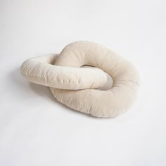 two round pillows sitting next to each other on top of a white surface with no one around them