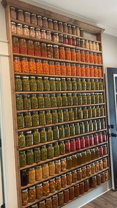 a wooden shelf filled with lots of jars and spices on top of it's sides