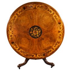 an ornately decorated wooden table with black and gold designs on the top, against a white background