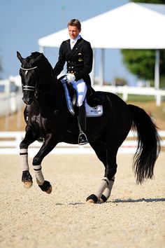 a woman riding on the back of a black horse