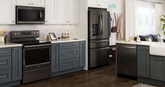 a kitchen with gray cabinets and white counter tops, stainless steel appliances in the center