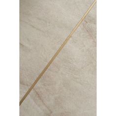 a white marble floor with gold trimmings and a wooden stick in the middle