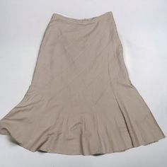 a tan skirt is laying on a white surface with the bottom section folded up and there are no shoes in it