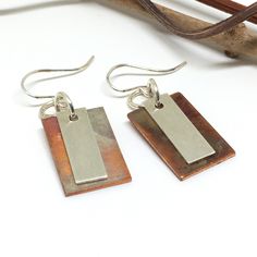 if you are looking to add a special touch to your outfit or need a unique gift, these handmade copper and sterling silver dangle earrings would be perfect. Because of their rich colors and smooth design, these earrings are great to wear to go out with friends or at work, making you feel wonderful and stylish. These earrings are perfect to indulge yourself or as a gift to give joy to someone else for their birthday, graduation, Mother's Day, Christmas, or just to show her some love! The copper on these earrings has been treated with heat bringing unique colors to the rectangle making each one different and allowing the copper not to tarnish, because of this no one earrings will have the same colors. The sterling silver rectangle has been textured. Each piece is handmade by me. The drop leng Handmade Rectangular Minimalist Earrings, Handmade Minimalist Rectangular Earrings, Everyday Silver Copper Earrings, Soldered Copper Earrings As A Gift, Unique Soldered Drop Earrings, Handmade Rectangular Copper Earrings, Everyday Soldered Dangle Earrings, Single Copper Earring As Gift, Minimalist Silver Copper Earrings