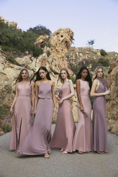 bridesmaids in dusty pink dresses posing for the camera