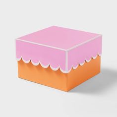 an orange and pink box with scalloped edges on a white background, it appears to be empty