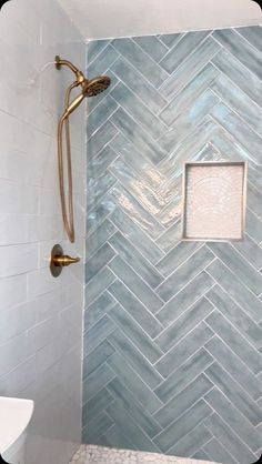 a white toilet sitting under a shower next to a tiled wall and floor in a bathroom