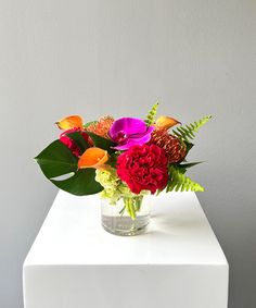 a vase filled with colorful flowers on top of a white table