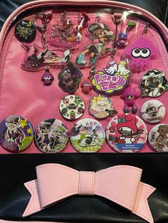 a pink purse with lots of different badges on it