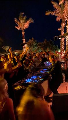 a group of people sitting around a table with laptops on it at night time