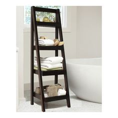 a ladder shelf with towels on it in front of a bathtub