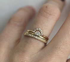 a close up of a person's hand with two rings on their fingers and one has a heart shaped diamond in the middle