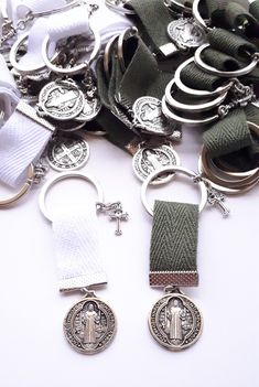 several key chains with medals on them laying next to each other and one has a cross