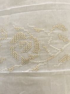 an embroidered piece of cloth with white thread