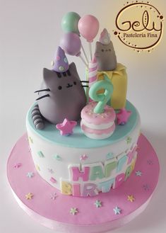 a birthday cake with two cats and balloons on the top, in pastel colors