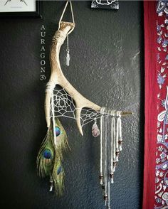 a dream catcher hanging on the wall next to a red curtain