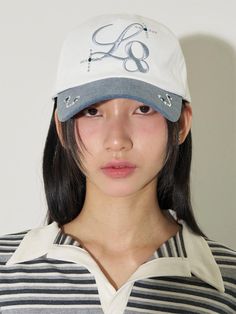 a woman wearing a baseball cap with scissors on it's brimmings