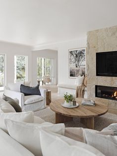 a living room filled with furniture and a fire place in the middle of the room