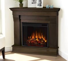 a living room with a fire place and pictures on the wall above it's mantle