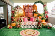 an outdoor seating area is decorated with flowers and greenery on the roof top terrace