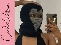 a woman wearing a black and white crochet mask holding up her cell phone