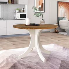 a white table sitting on top of a wooden floor next to a living room filled with furniture