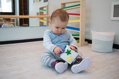 a small child sitting on the floor playing with a toy