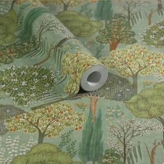 a roll of fabric with trees and bushes printed on it, sitting in front of a green background