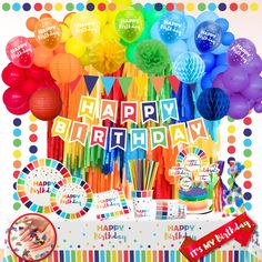 a birthday party with balloons, streamers, and paper decorations on a table in front of a rainbow colored backdrop