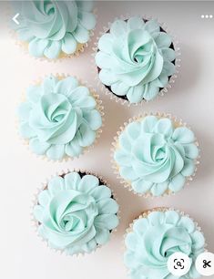 four cupcakes with frosting on them sitting next to each other in front of a white background