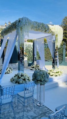 an outdoor wedding setup with white flowers and chairs