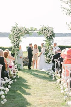 a bride and groom are walking down the aisle at their wedding ceremony by the water