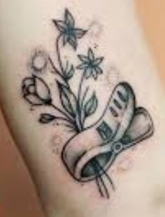 a small tattoo with flowers and scissors on the side of her leg, which is black and white