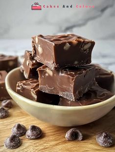 a bowl full of chocolate fudges on top of a wooden table with nuts