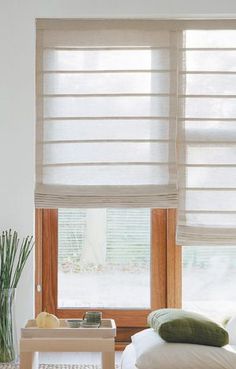 a living room with white walls and wooden blinds